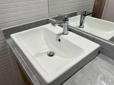a white sink in a bathroom with two mirrors at Design Apartment with city view! - Miraflores in Lima