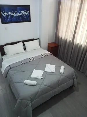 a bedroom with a large bed with towels on it at Habitación cama QUEEN 1B in Lima