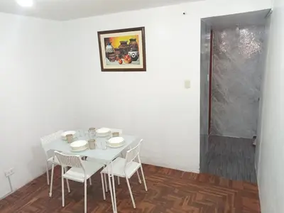 a white dining room with a white table and chairs at Habitación cama QUEEN 1B in Lima