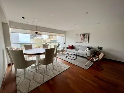 a dining room and living room with a table and chairs at Malecón Miraflores Luxury Penthouse in Lima
