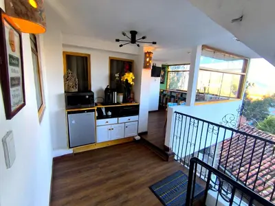 a kitchen with white cabinets and a staircase at Patrick's Day Home Cusco in Cusco