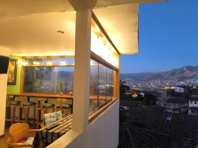 a balcony with a view of a city at night at Patrick's Day Home Cusco in Cusco