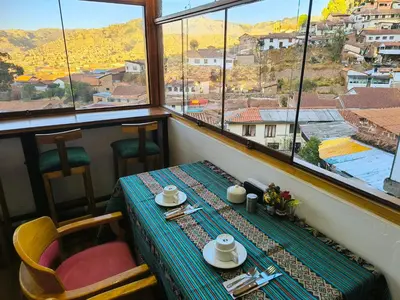 a table in a room with a view of a city at Patrick's Day Home Cusco in Cusco