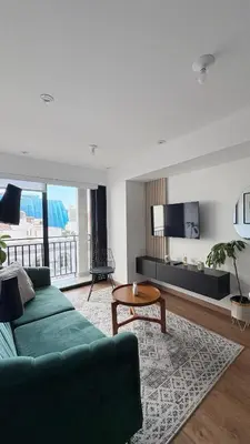 a living room with a green couch and a tv at Apartment 2BDR next to Javier Prado - San Isidro in Lima
