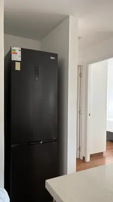 a black refrigerator in a room with a kitchen at Apartment 2BDR next to Javier Prado - San Isidro in Lima