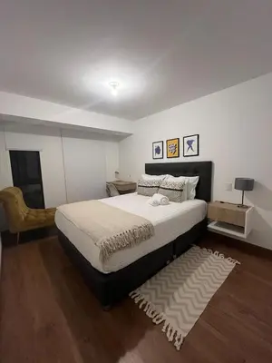 a bedroom with a large bed and a chair at Apartment 2BDR next to Javier Prado - San Isidro in Lima