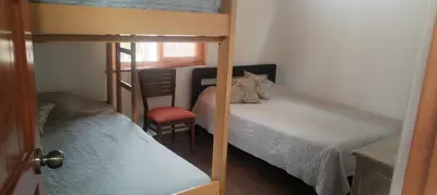 a small room with two bunk beds and a chair at Bungalow 23 in El Carmen