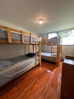 a room with three bunk beds and a wooden floor at casa Alva in La Molina