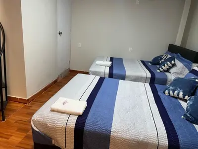 two beds in a room with blue and white at Minidepartamento de 3 pisos, completo y comodo in Cusco