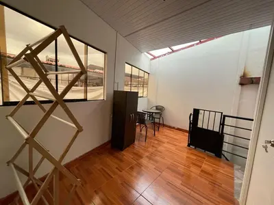 a room with a staircase and a table and chairs at Minidepartamento de 3 pisos, completo y comodo in Cusco