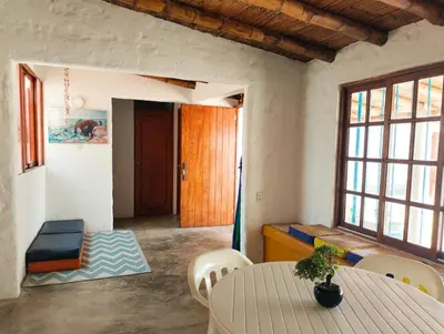 a living room with a table and chairs and a door at Casa bonita en Playa Los Lobos in Cerro Azul
