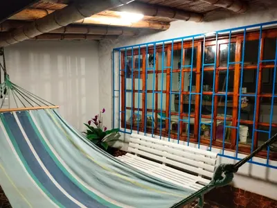 a hammock in a room next to a window at Casa bonita en Playa Los Lobos in Cerro Azul