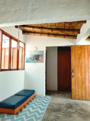 a room with a blue couch and a wooden door at Casa bonita en Playa Los Lobos in Cerro Azul