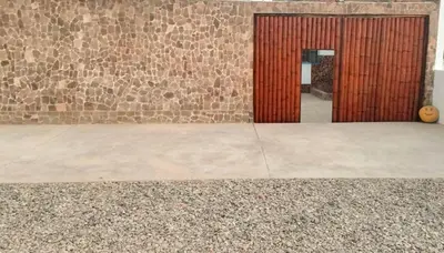 a door to a building with a stone wall at Casa bonita en Playa Los Lobos in Cerro Azul
