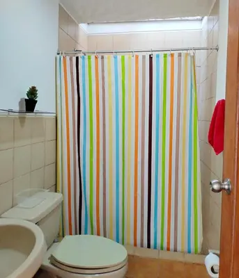 a colorful shower curtain in a bathroom with a toilet at Casa bonita en Playa Los Lobos in Cerro Azul