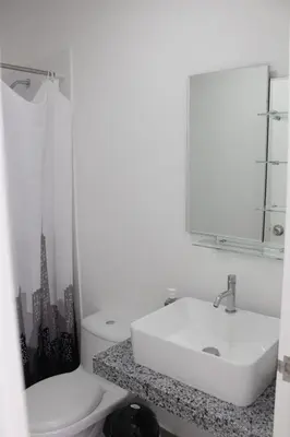 a white bathroom with a sink and a toilet at Apartamento Mary in Lima