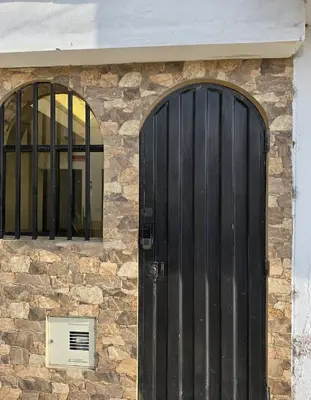 a building with a black door and two windows at Cuzco Lodgement in Lima