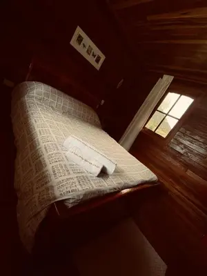 a bed in a room with a window at Yoly cabaña in Oxapampa