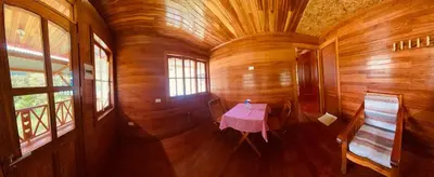 an empty room with a table in a wooden house at Yoly cabaña in Oxapampa