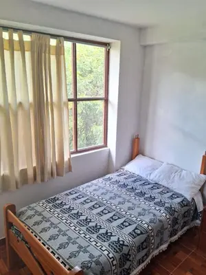 a bed in a bedroom with a window at Guest House Aylluq Wasin in Urubamba