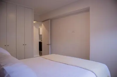 a white bedroom with a bed and a closet at Art by Wynwood House in Lima