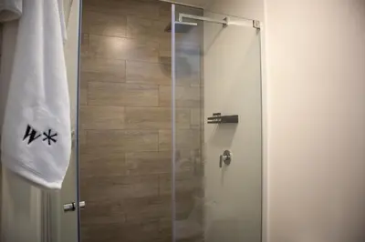 a shower with a glass door in a bathroom at Art by Wynwood House in Lima