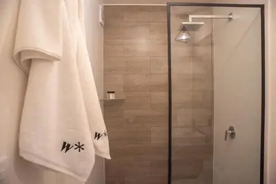 a bathroom with a shower with a glass door at Art by Wynwood House in Lima