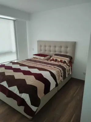 a large bed with a brown and white comforter at Departamento de 3 habitaciones in Lima