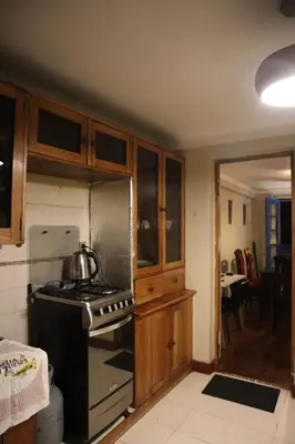 a kitchen with wooden cabinets and a stove top oven at Casa Canal - 3 cuadras de la Plaza de Armas in Cusco