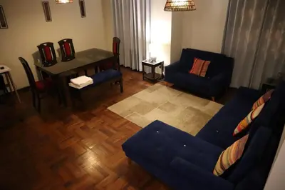 a living room with a blue couch and a table at Casa Canal - 3 cuadras de la Plaza de Armas in Cusco