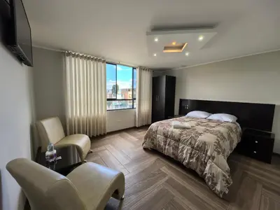 a bedroom with a bed and a desk and chair at Hotel Douce Nuit in Huancayo