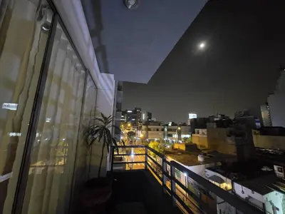 a balcony with a view of a city at night at Departamento en el Corazón de Miraflores Peru in Lima