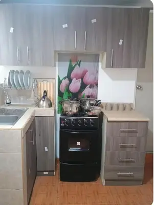 a kitchen with a black stove and a sink at Departamento Acogedor en Surco in Lima