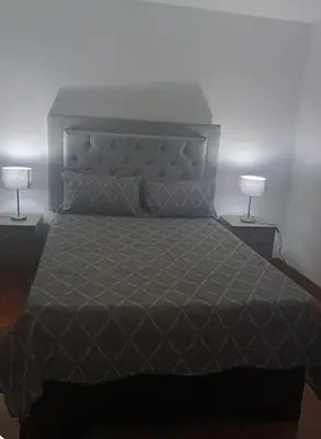 a bedroom with a large bed with two lamps at Departamento Acogedor en Surco in Lima