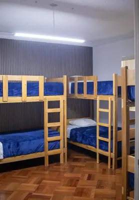 a room with three bunk beds with blue sheets at Gutierrez Hostel in Lima