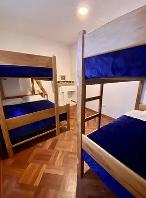 two bunk beds in a room with wooden floors at Gutierrez Hostel in Lima
