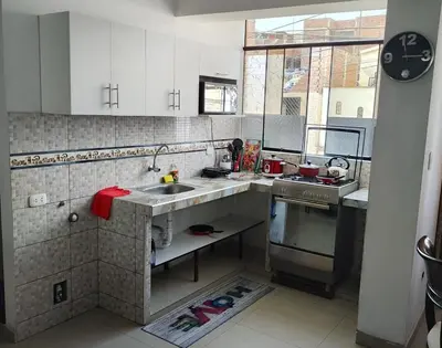a kitchen with white cabinets and a sink at Apartment 10 minutes from the airport in Lima