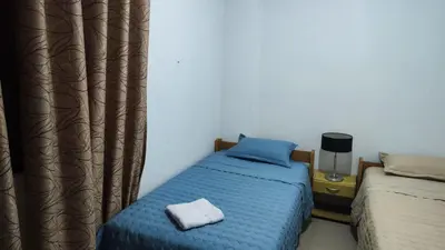 a bedroom with a bed with a blue comforter at Apartment 10 minutes from the airport in Lima
