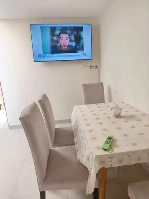a table and chairs with a television on a wall at Apartment 10 minutes from the airport in Lima