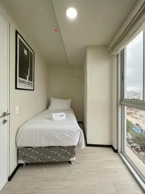 a small bedroom with a bed and a window at Pionero by geko in Lima