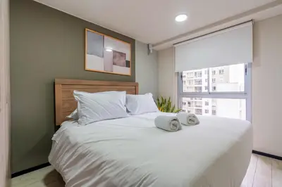 a bedroom with a large bed with two towels on it at Pionero by geko in Lima
