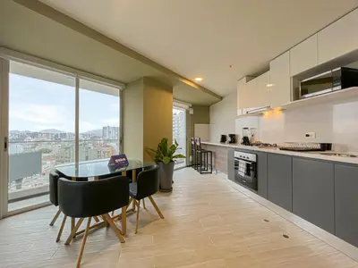 a kitchen with a table and chairs and a large window at Pionero by geko in Lima