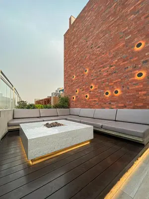 a couch on a deck with a brick wall at Pionero by geko in Lima