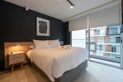 a bedroom with a large bed and a large window at Pionero by geko in Lima