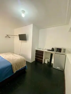 a bedroom with a bed and a desk and a lamp at Habitaciones Independientes Av Larco in Lima