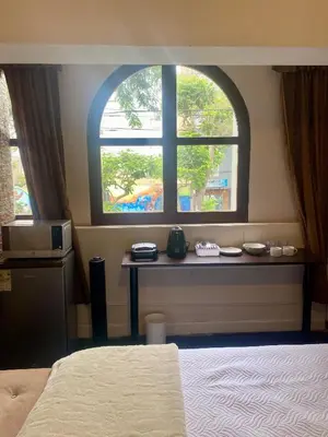 a room with a bed and a window with a table at Habitaciones Independientes Av Larco in Lima