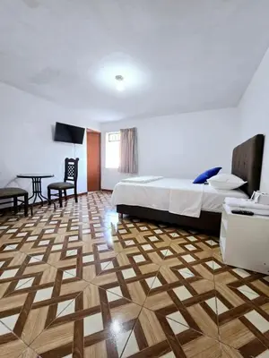 a hotel room with a bed and a table at Los Angeles Hotel in Huaral