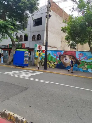 a person walking down a street in front of a mural at Céntrica y amplia habitación queen Av Larco in Lima