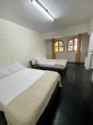 a bedroom with two beds and two windows at Amplia habitación dos camas dobles Miraflores in Lima