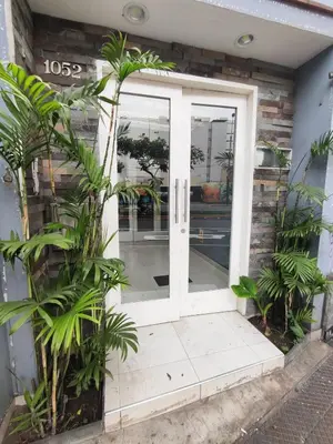 a white door with plants in front of a building at Amplia habitación dos camas dobles Miraflores in Lima